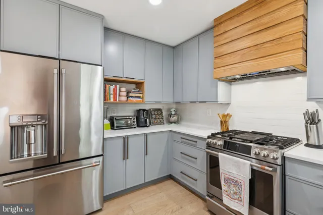 a kitchen with stainless steel appliances white cabinets and a stove top oven