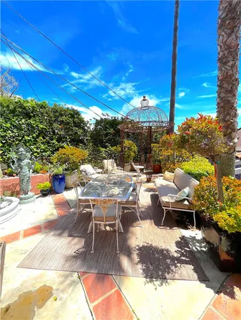 a view of a patio with couches table and chairs under an umbrella