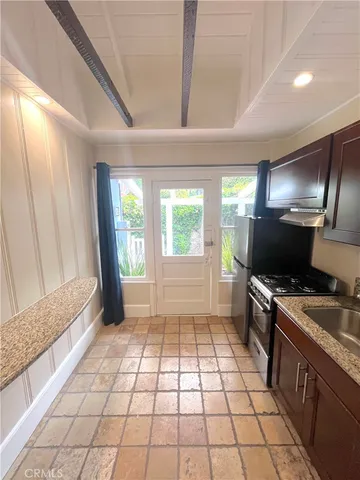 a kitchen with granite countertop a stove a sink and a refrigerator