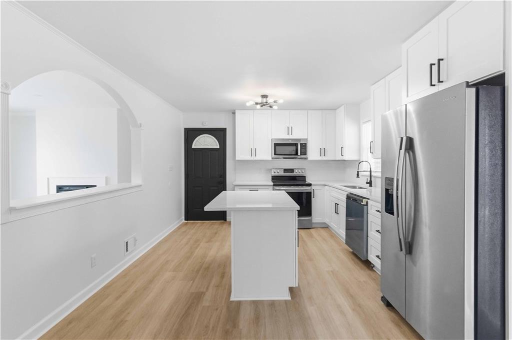 2275 Country Club Lane Southwest Atlanta, GA 30311 - Photo 11 of 32 a kitchen with refrigerator cabinets and wooden floor
