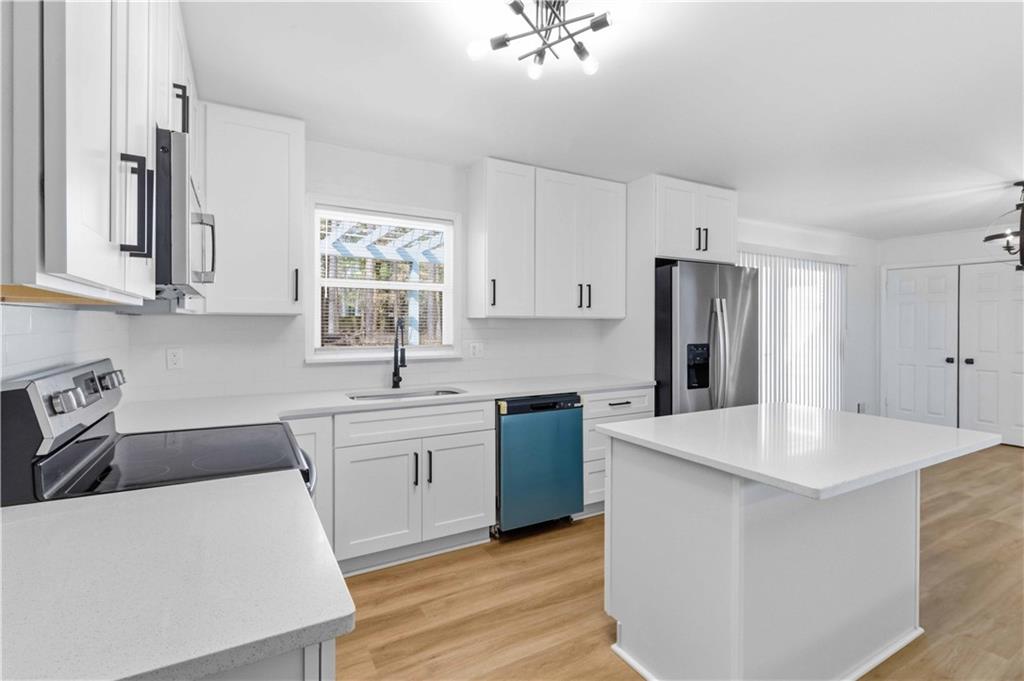 2275 Country Club Lane Southwest Atlanta, GA 30311 - Photo 10 of 32 a kitchen with stainless steel appliances granite countertop a sink a stove a refrigerator and white cabinets