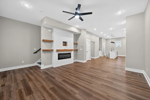a view of empty room with kitchen and window