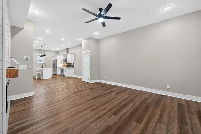 a view of empty room with wooden floor and ceiling fan