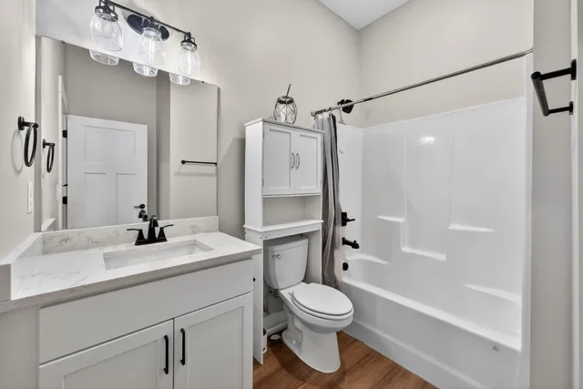 a bathroom with a sink a toilet and shower