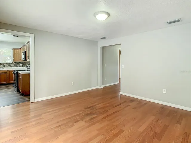 a view of an empty room with wooden floor