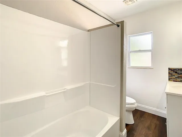 a front view of a house with a yard and covered with trees