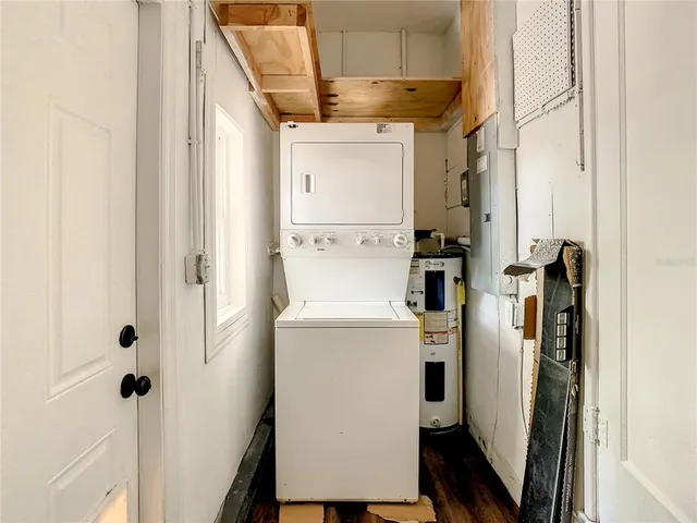 a backyard of a house with table and chairs under a large tree