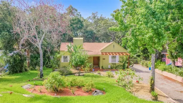an empty room with wooden floor fireplace and windows