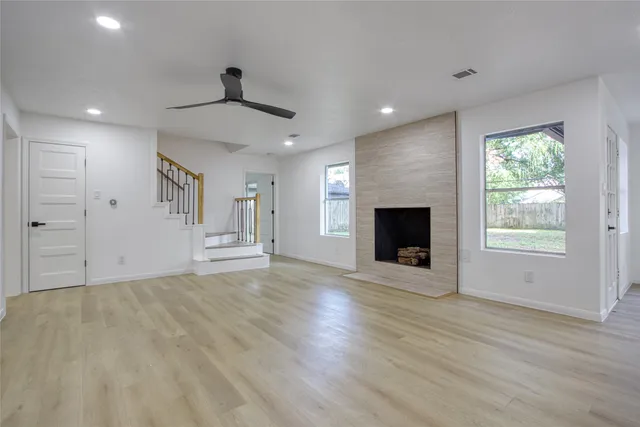 a view of an empty room with a fireplace and a window