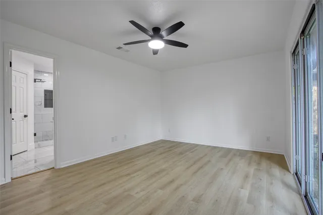 a view of an empty room with wooden floor