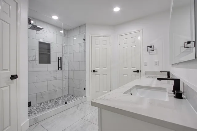 a bathroom with a shower sink and mirror