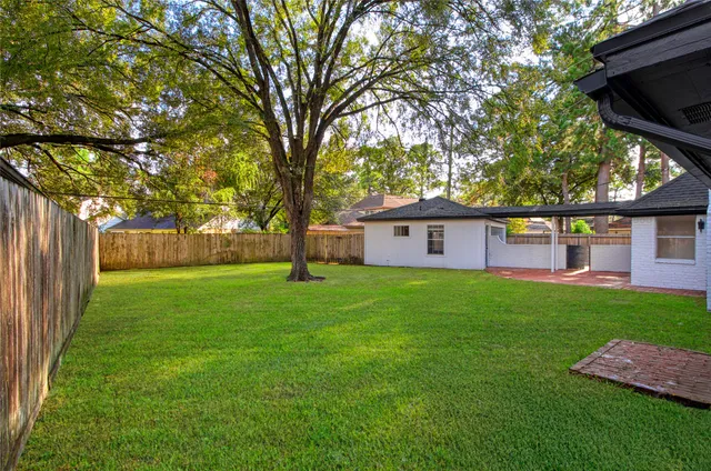 a view of a yard with a house and a large tree