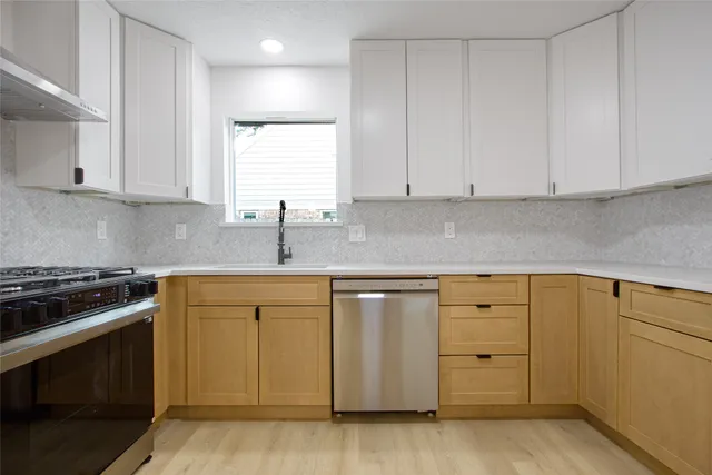 a kitchen with granite countertop white cabinets and stainless steel appliances