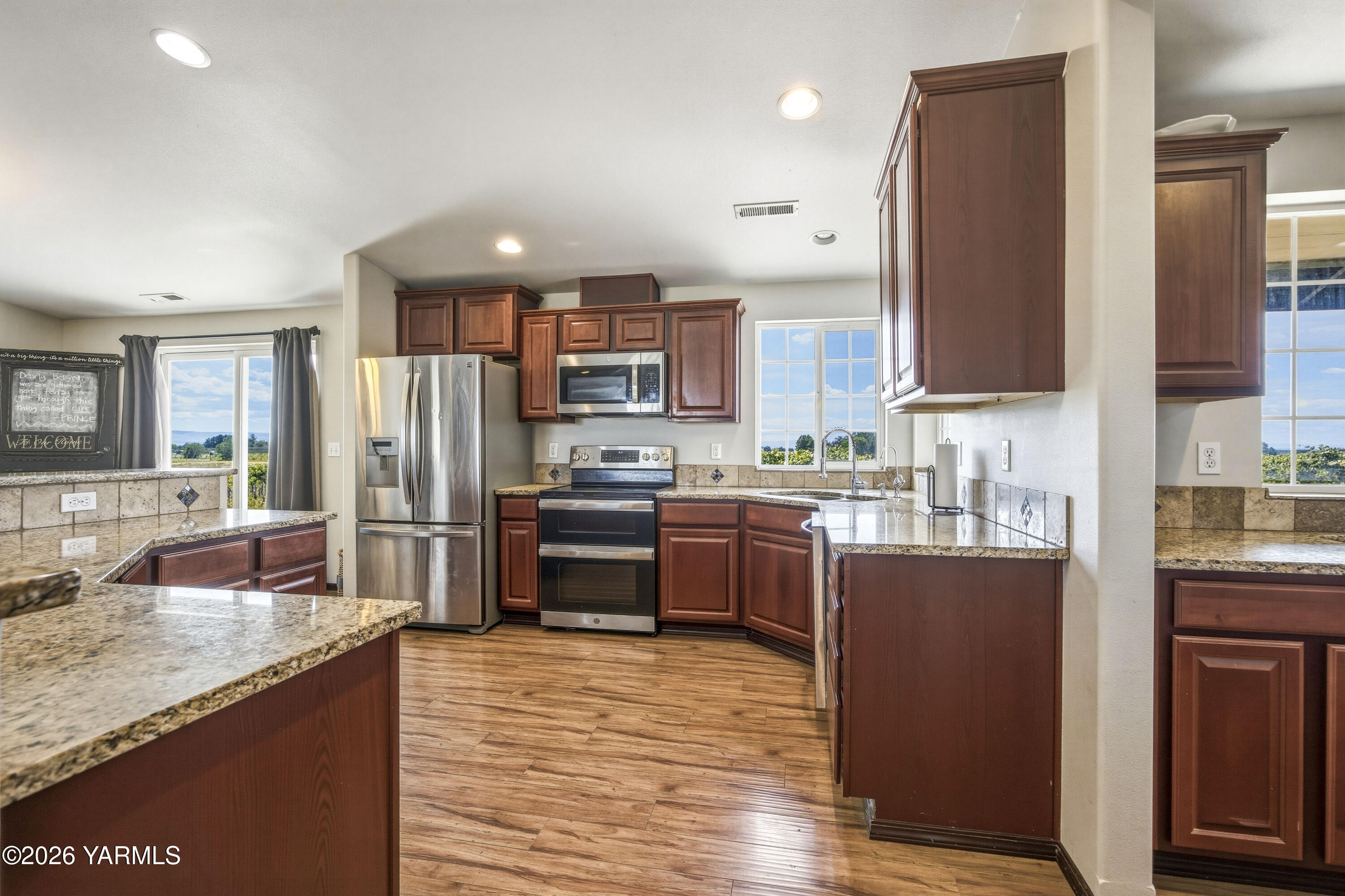 2050 Olmstead Road Grandview, WA 98930 - Photo 33 of 60 a kitchen with stainless steel appliances kitchen island granite countertop a refrigerator a stove top oven and a sink