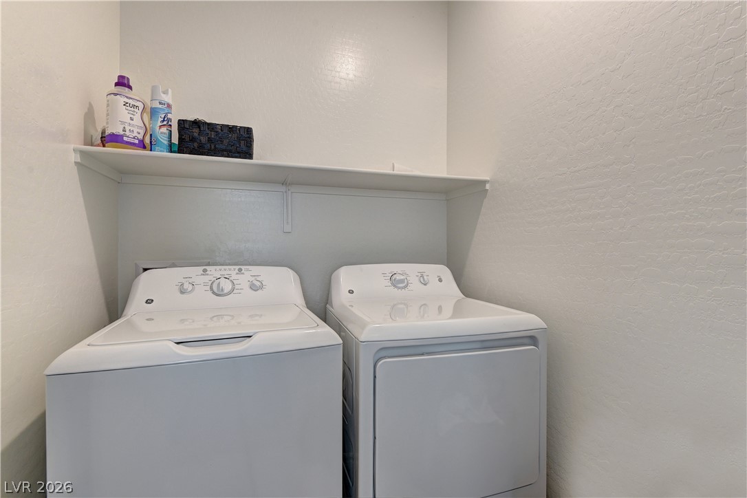 8827 Roadrunner Ravine Street Las Vegas, NV 89166 - Photo 5 of 17 Laundry area featuring a textured wall and washer and clothes dryer