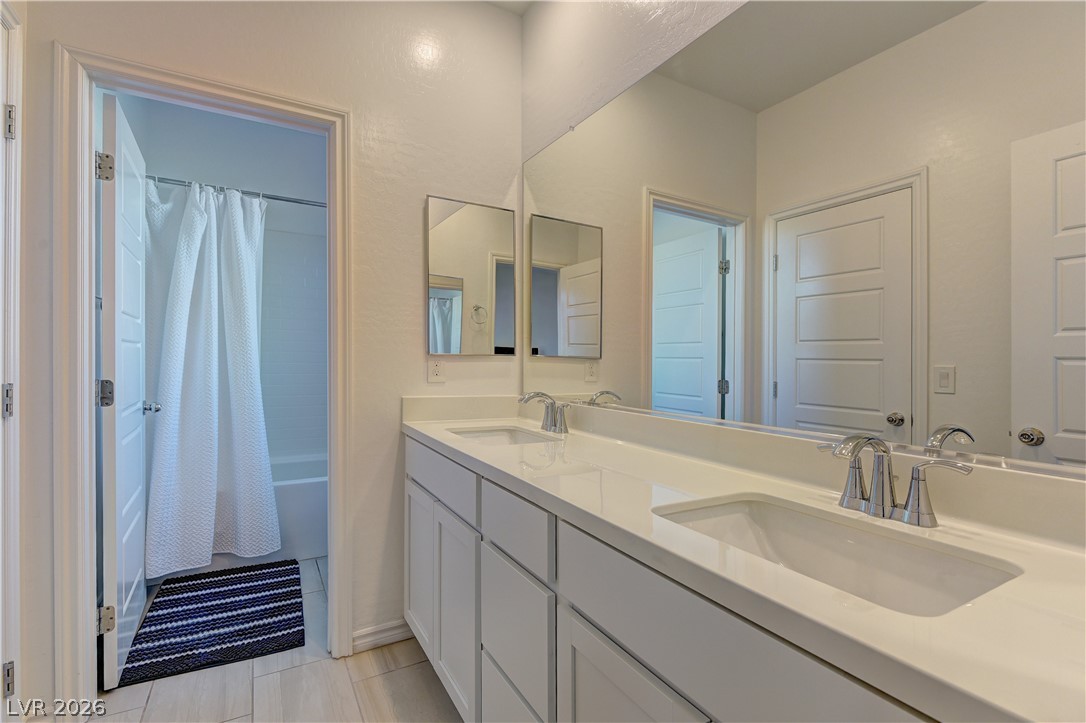 8827 Roadrunner Ravine Street Las Vegas, NV 89166 - Photo 7 of 17 Full bath with double vanity and shower / tub combo with curtain
