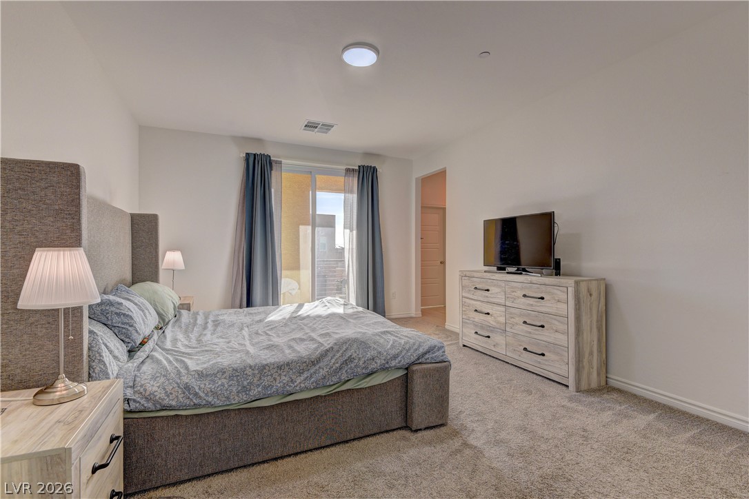8827 Roadrunner Ravine Street Las Vegas, NV 89166 - Photo 10 of 17 Bedroom with light carpet and baseboards