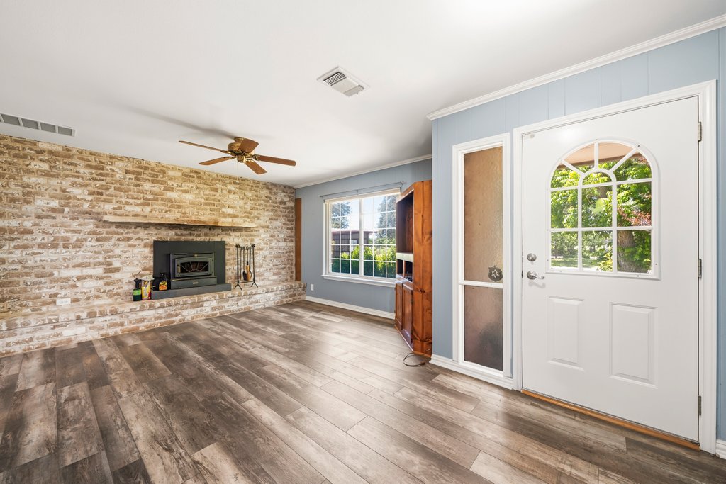 1961 Bolton Road Marion, TX 78124 - Photo 6 of 17 an empty room with windows fireplace and wooden floor