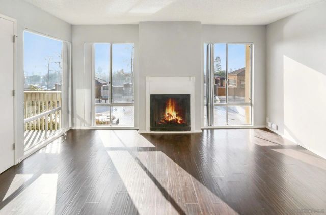 a view of empty room with wooden floor and fireplace