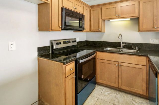 a kitchen with stainless steel appliances granite countertop a sink stove and microwave