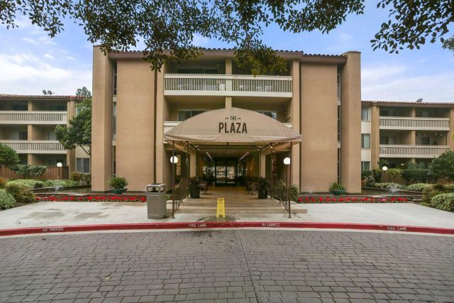 a view of a brick building with a fountain in front of it