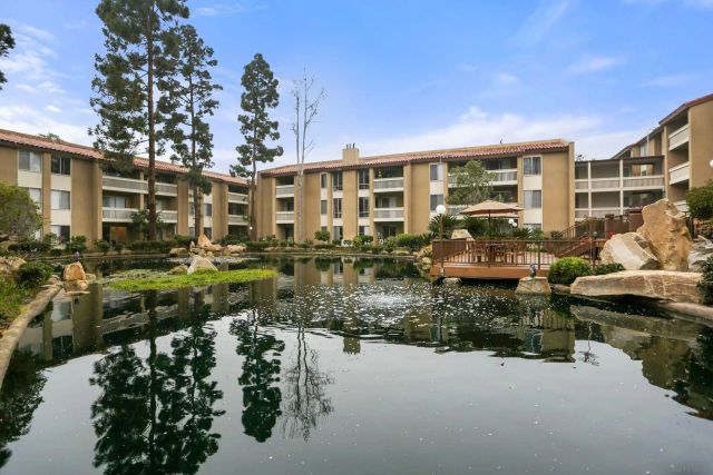 a front view of a house with a yard and lake view