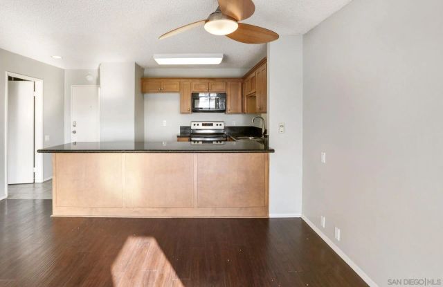 a large white kitchen with wooden floor