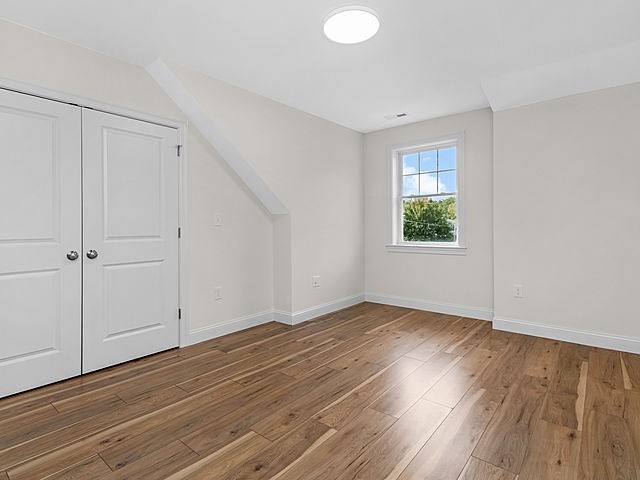 1 Pleasant Street, Unit 301 Cohasset, MA 02025 - Photo 6 of 20 a view of an empty room with wooden floor and a window