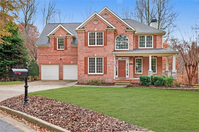 a front view of a house with a yard and trees