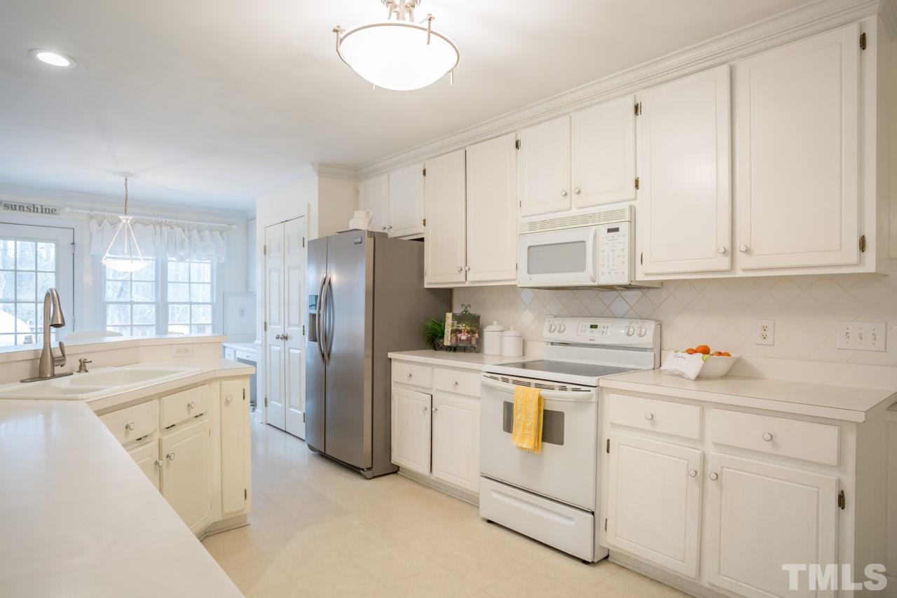2716 Dahlgreen Road Raleigh, NC 27615 - Photo 7 of 25 a kitchen with white cabinets and white appliances
