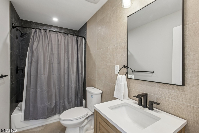 85 Madison Street Newton, NJ 07860 - Photo 22 of 45 a bathroom with a sink a toilet a mirror and shower curtain