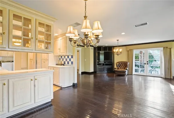 a view of a living room and kitchen with furniture wooden floor chandelier