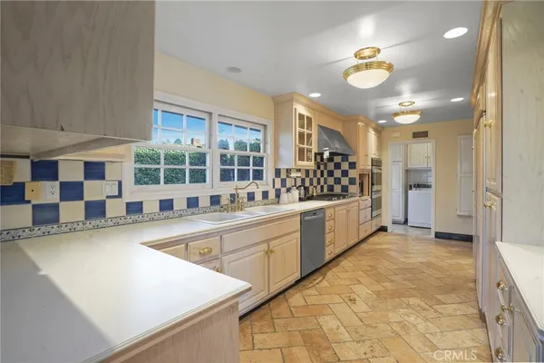 a large white kitchen with a large window cabinets and stainless steel appliances