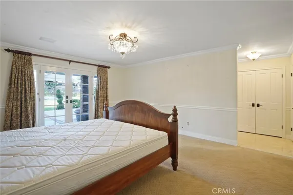 a bedroom with a large bed and a chandelier