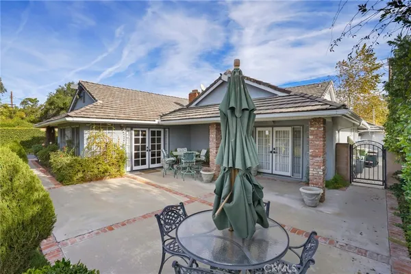 a view of a house with a chairs and table in a patio