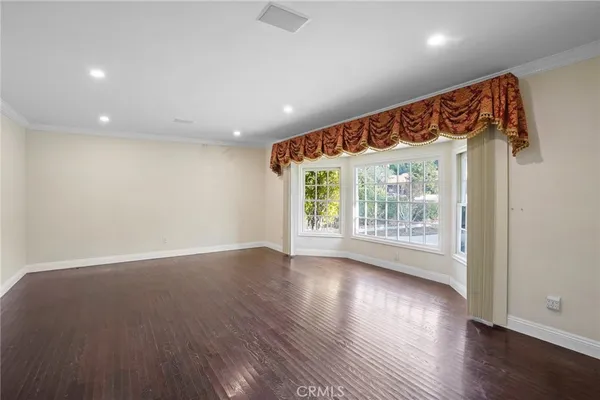 an empty room with wooden floor and a window