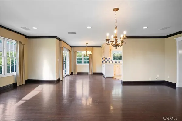 a view of a livingroom with wooden floor and a chandelier