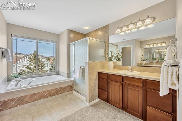 13884 Windy Oaks Road Colorado Springs, CO 80921 - Photo 14 of 21 Bathroom with tile patterned floors, vanity, a bath, and a shower stall