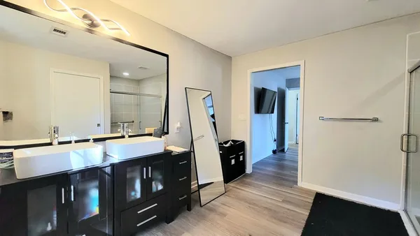 a bathroom with double vanity and a mirror