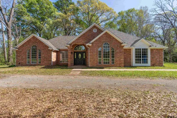 a front view of a house with a garden and yard