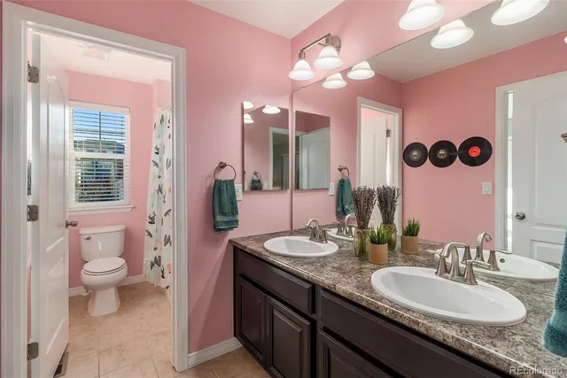 a bathroom with a granite countertop sink a toilet and a mirror