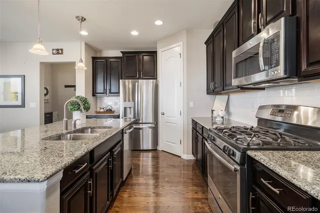 a kitchen with stainless steel appliances granite countertop a sink stove and refrigerator