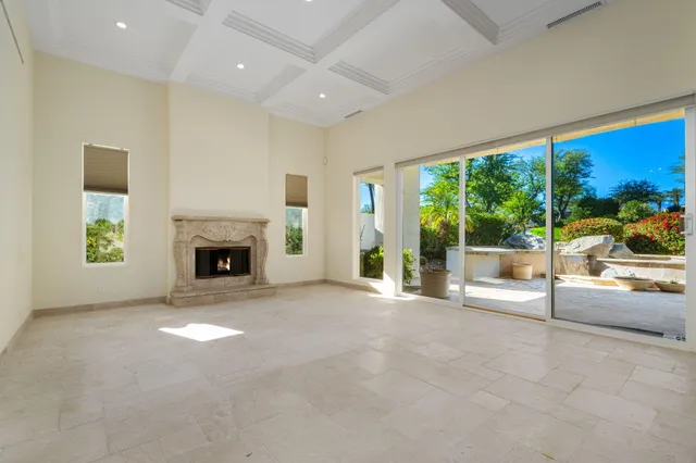 an empty room with floor to ceiling windows and yard