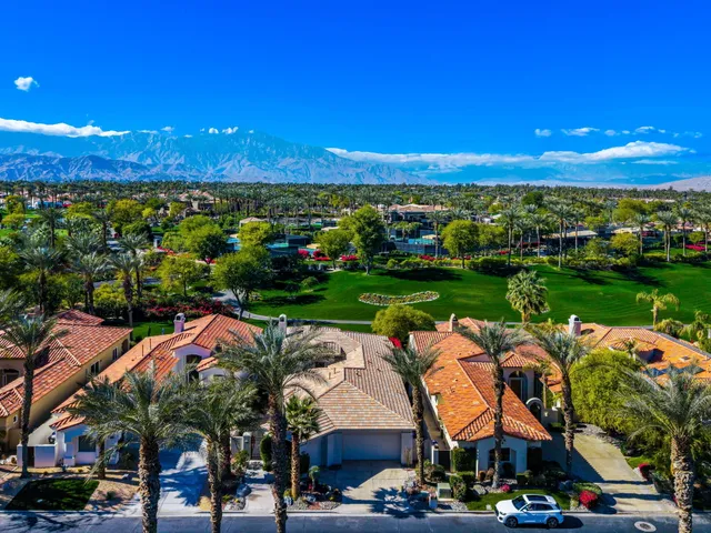 a view of a house with palm tree and a small yard