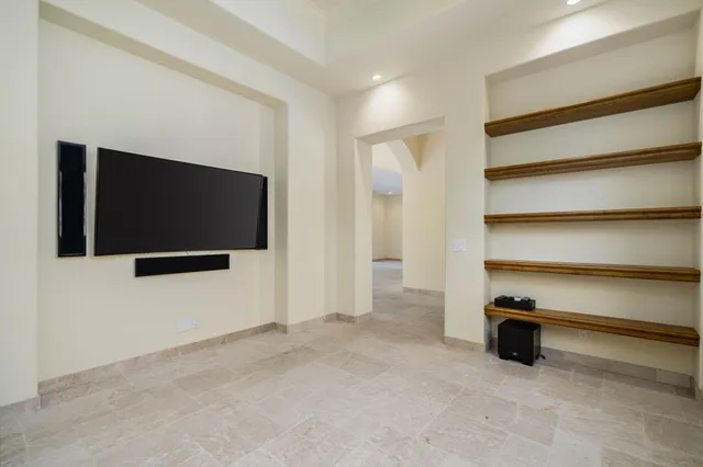 an empty room with windows and fireplace