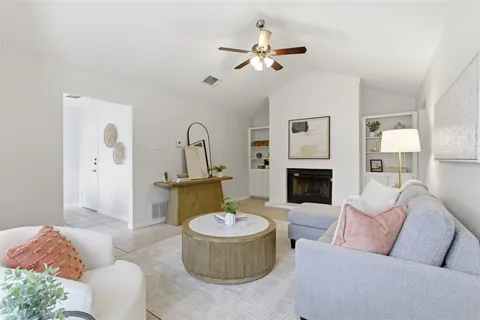 a living room with furniture a fireplace and a chandelier