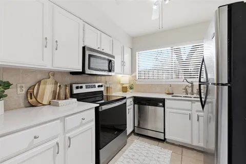 a kitchen with granite countertop white cabinets and white appliances