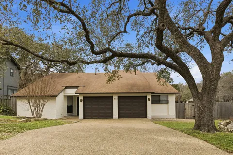front view of a house with a large tree