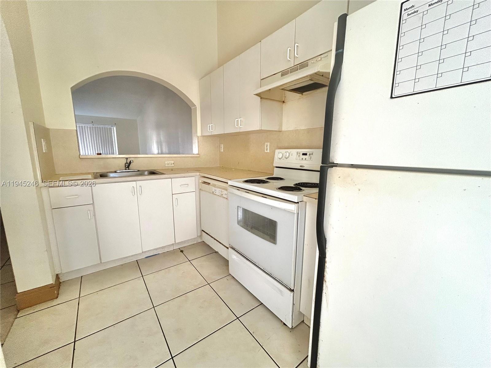1250 Southeast 29th Street, Unit 20258 Homestead, FL 33035 - Photo 8 of 13 a kitchen with a stove a sink and a refrigerator