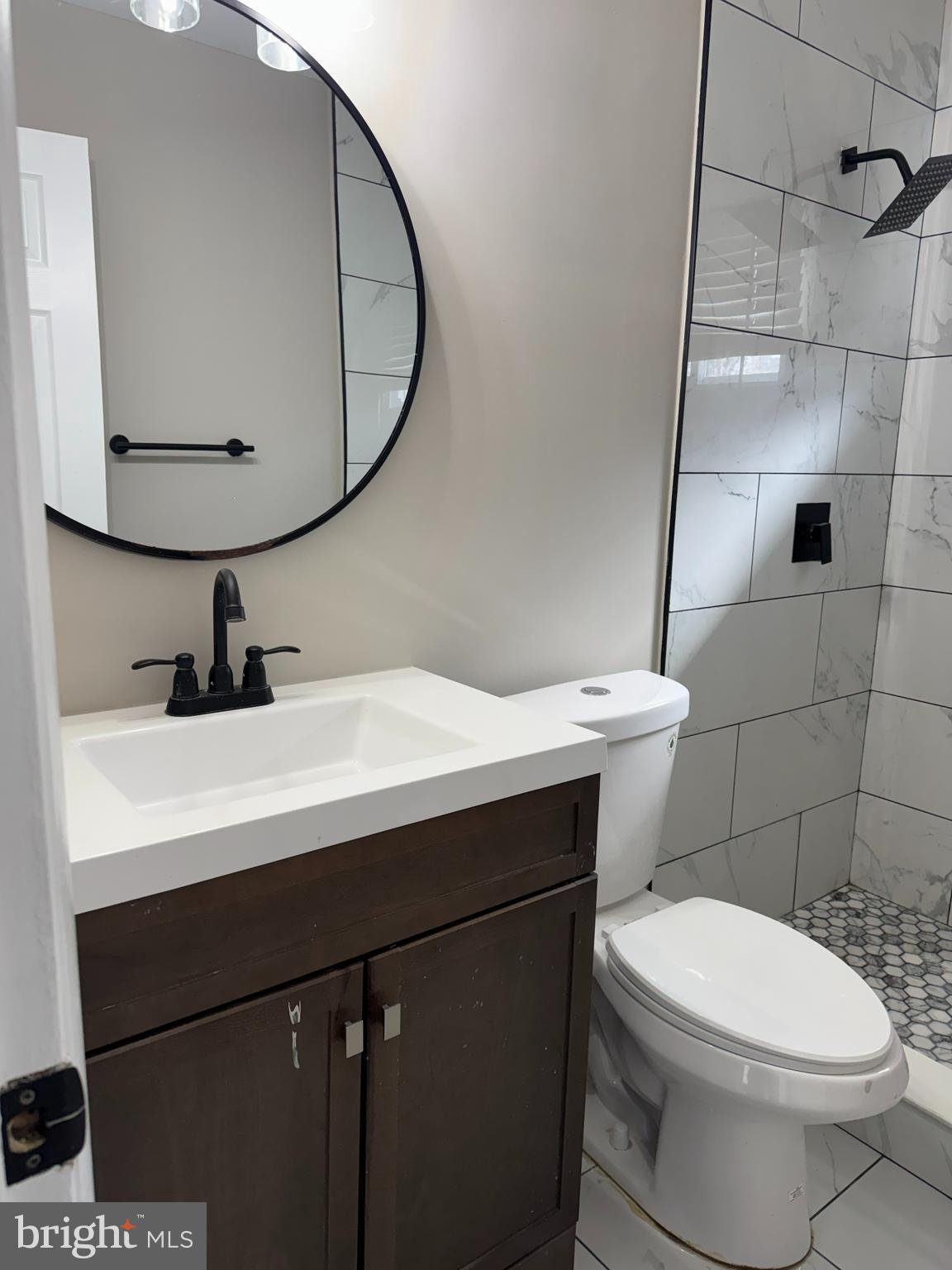 8313 26th Avenue Adelphi, MD 20783 - Photo 11 of 17 a bathroom with a sink a mirror and a toilet